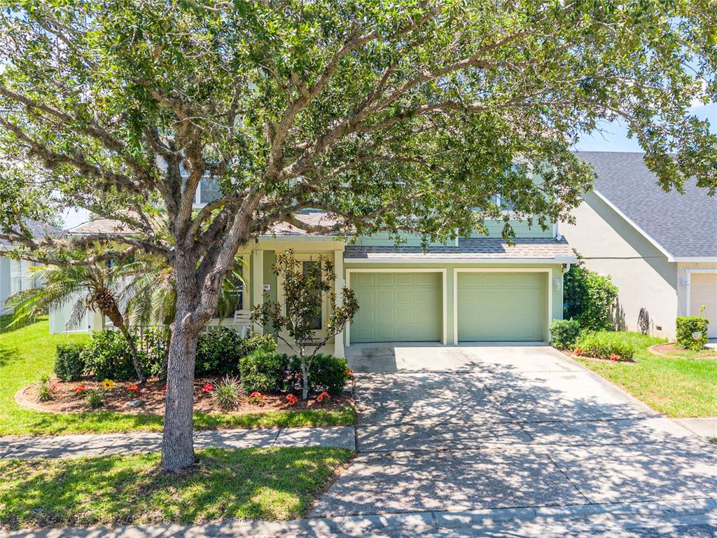 A two-story light green house with a two-car garage and a large front tree — 4930 ATWOOD DRIVE, ORLANDO, FL