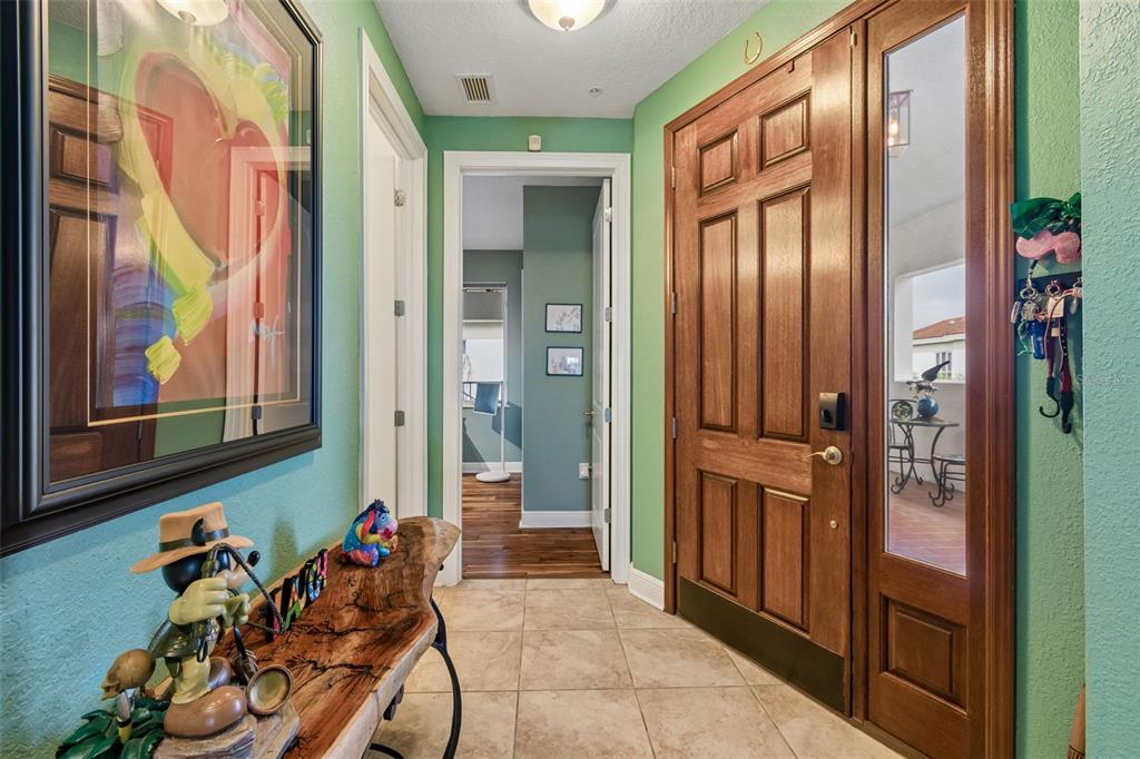An entryway features a wooden front door, tile flooring, green walls, and a live-edge console — 1038 BELLASOL WAY UNIT 403, APOLLO BEACH, FL