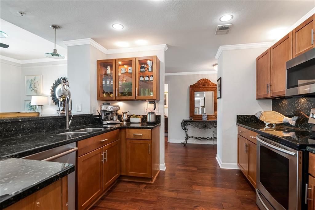 A kitchen with wood cabinets, dark granite countertops, and stainless steel appliances — 345 BAYSHORE BOULEVARD UNIT 808, TAMPA, FL