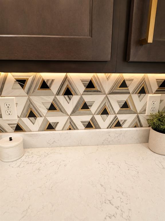 A kitchen backsplash features a geometric triangle pattern with marble, black, and gold accents — 1743 WILSON PRAIRIE CIRCLE, GROVELAND, FL