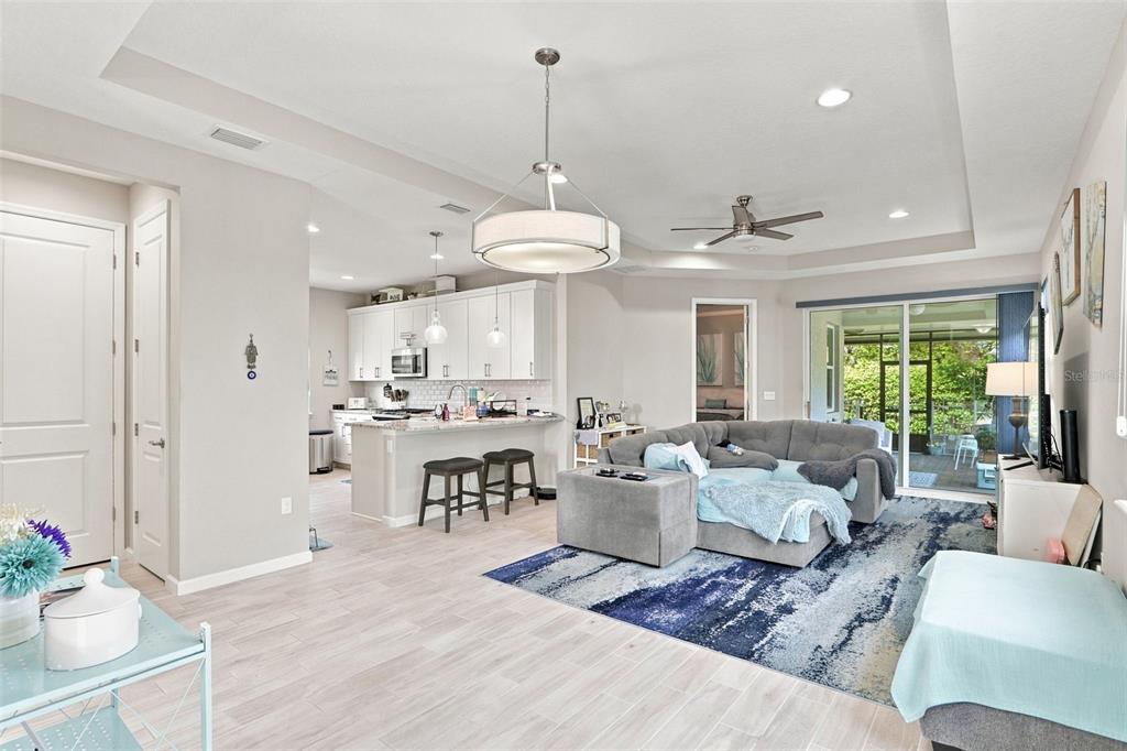 A living room features a grey sectional sofa, a blue area rug, and a ceiling fan — 177 OLD MOSS CIRCLE, DELAND, FL