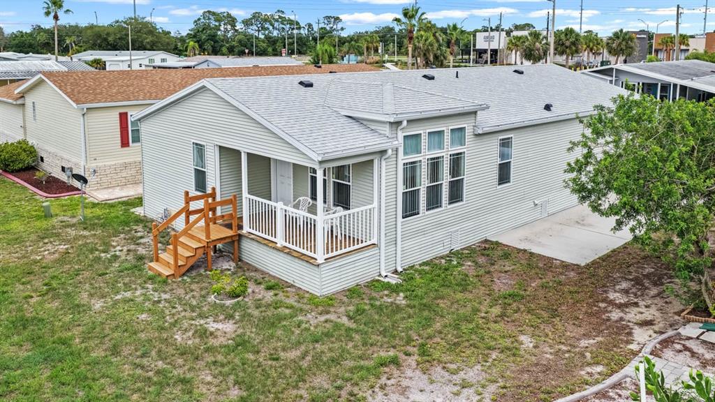 An elevated exterior view of a light-colored manufactured home with a front porch and deck — 209 S PORT ROYAL LANE, APOLLO BEACH, FL