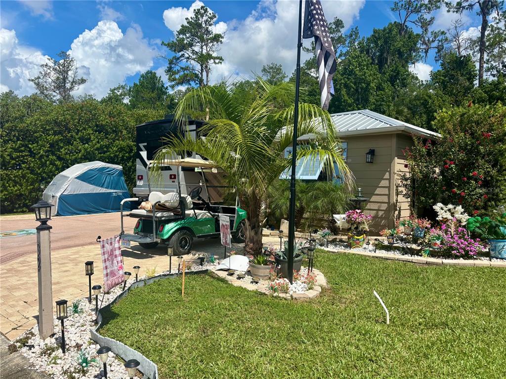A house with a metal roof, a golf cart, and a flag in the front yard — 10371 NE 28TH LOOP, SILVER SPRINGS, FL
