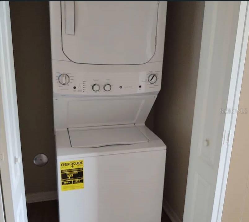 A white stacked washer and dryer unit is installed inside a small closet — 2609 LANDOVER BOULEVARD UNIT 2617, SPRING HILL, FL