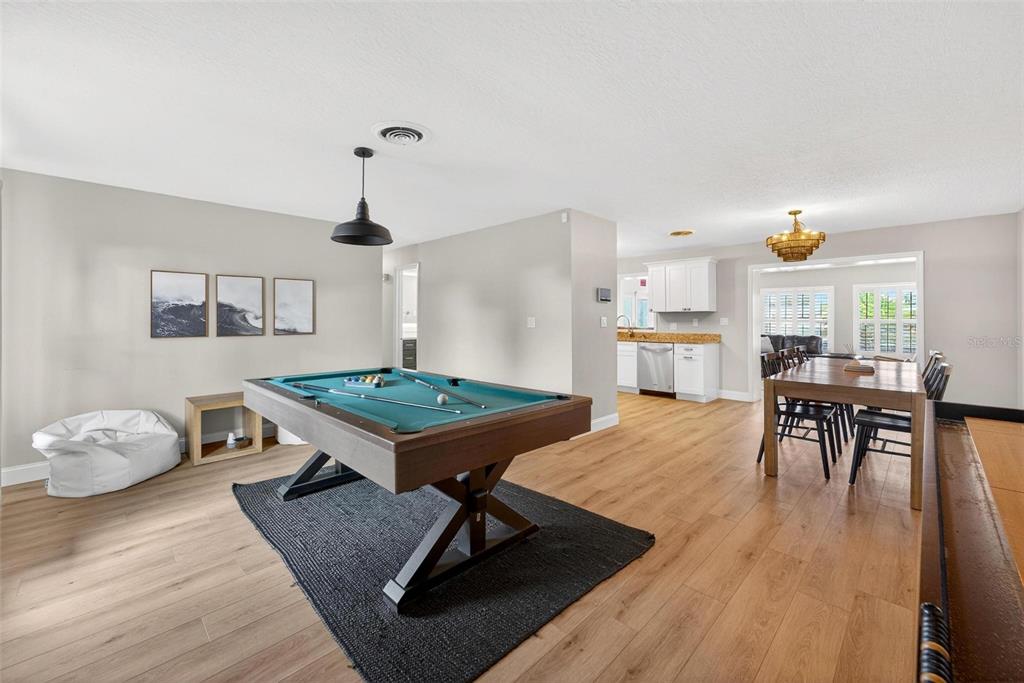 A game room features a pool table, light wood flooring, and an adjacent dining area — 113 DELEON ROAD, COCOA BEACH, FL