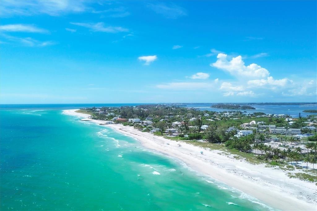 An aerial view of a white sand beach along a turquoise ocean with coastal homes — 616 LYONS LANE, LONGBOAT KEY, FL