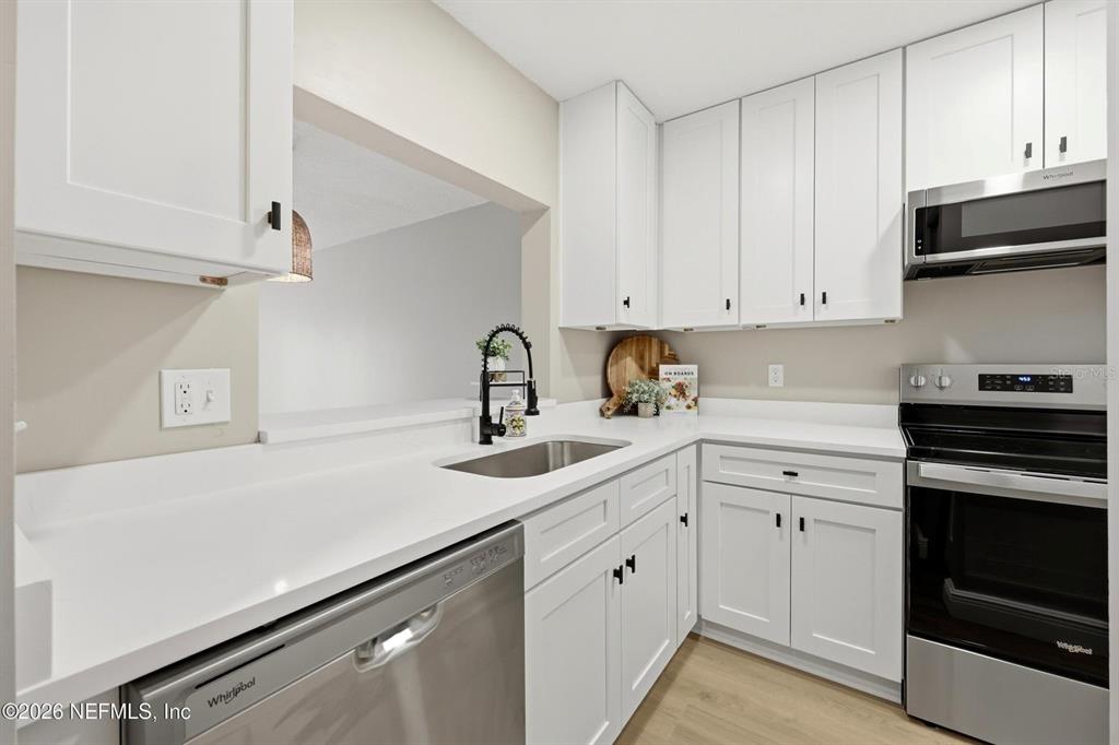 A kitchen features white cabinets, stainless steel appliances, and white countertops with a sink — 3801 CROWN POINT ROAD UNIT 2093, JACKSONVILLE, FL