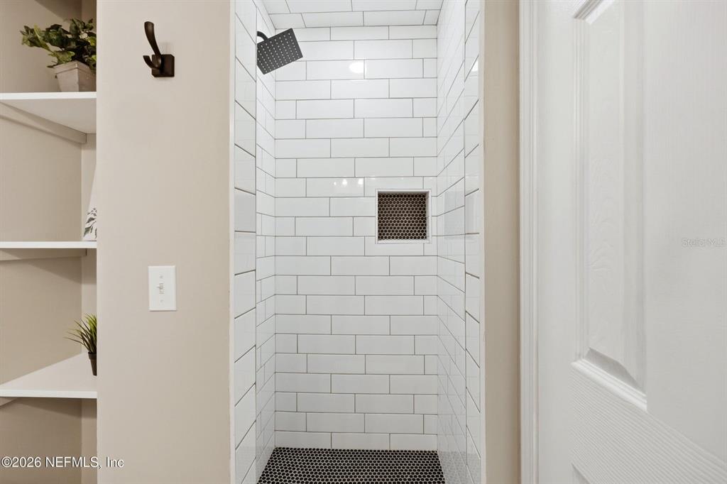 A walk-in shower features white subway tile walls, a black penny tile floor, and a niche — 3801 CROWN POINT ROAD UNIT 2093, JACKSONVILLE, FL