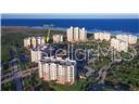 An aerial view shows a multi-building residential complex located near the ocean — 261 MINORCA BEACH WAY UNIT 203, NEW SMYRNA BEACH, FL