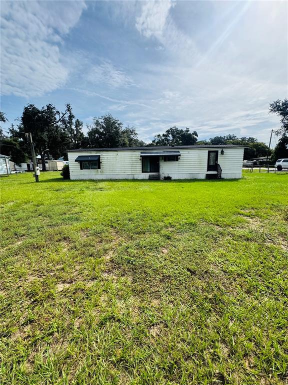 A single-story manufactured home with white siding sits on a large, grassy lot — 1013 LIANNE PLACE, SEFFNER, FL