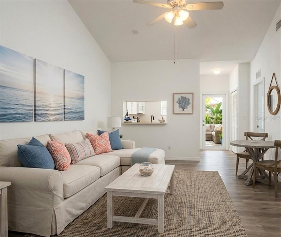 A living room with a sectional sofa, coffee table, dining set, and a kitchen pass-through — 8416 BERNWOOD COVE LOOP UNIT 1612, FORT MYERS, FL