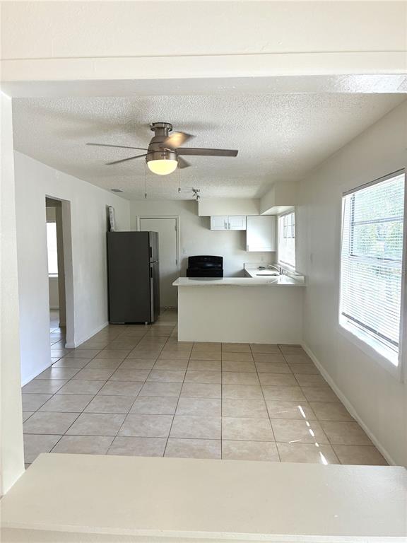 A kitchen with a breakfast bar, tile flooring, and a ceiling fan — 3605 E 28TH AVENUE, TAMPA, FL