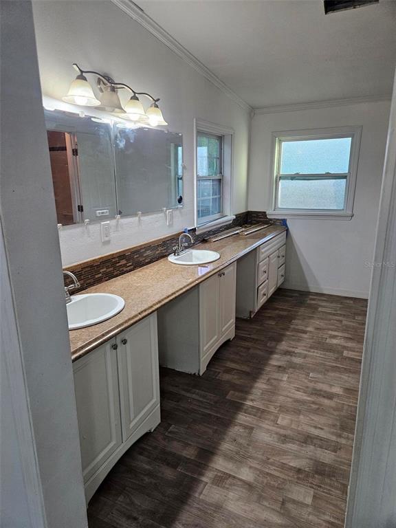 A kitchen features gray cabinets, a black stove, and a light blue tiled backsplash — 3050 CR 418, LAKE PANASOFFKEE, FL