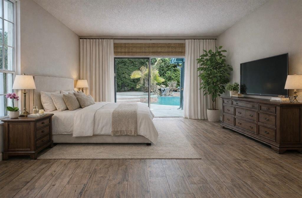 A swimming pool with a rock waterfall feature and a concrete deck at dusk — 9115 BAY SIDE COURT, ORLANDO, FL