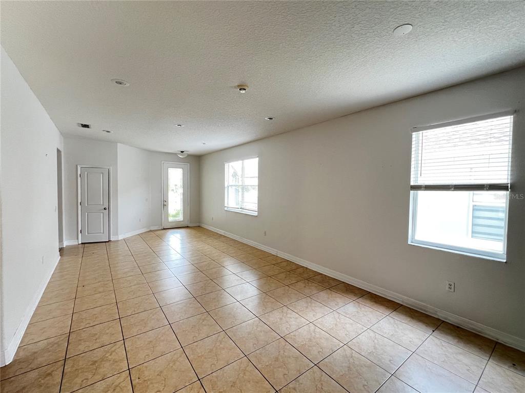 A living room features a beige sectional sofa, a coffee table, and tile flooring — 454 JANICE KAY PLACE, KISSIMMEE, FL
