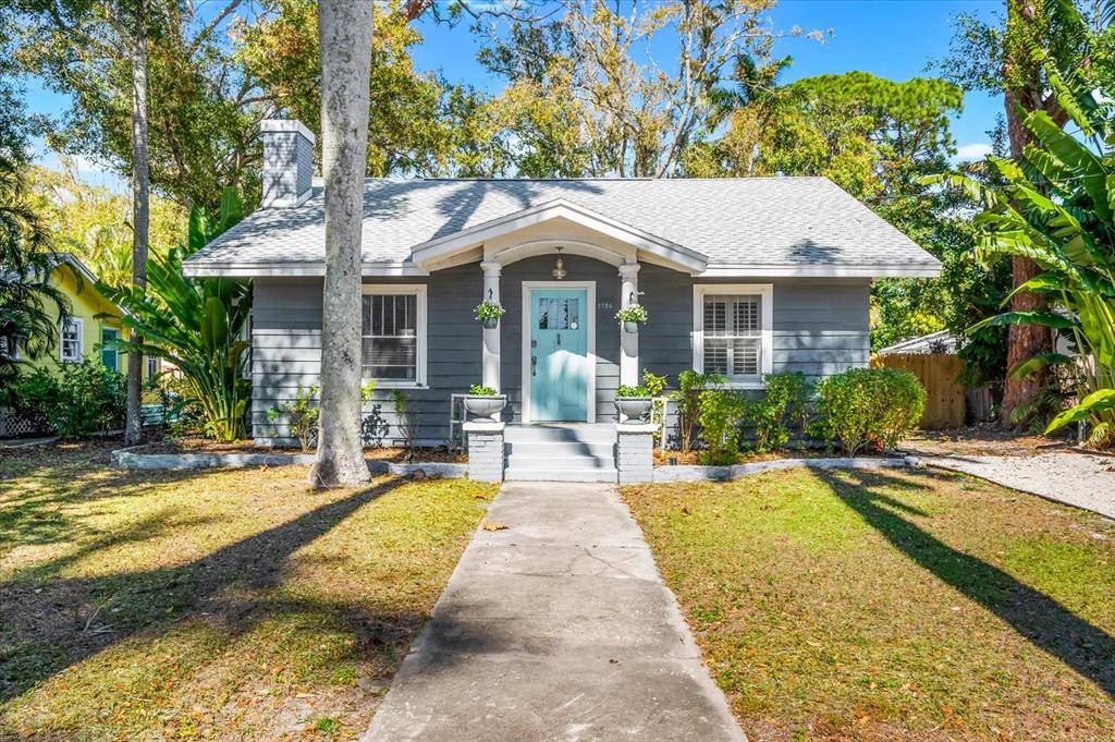 A gray, single-story house with a light blue front door and a concrete walkway — 2726 8TH AVENUE W, BRADENTON, FL