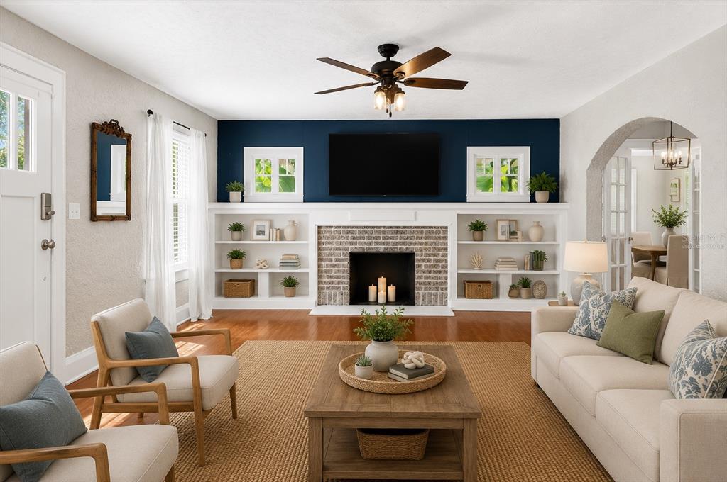 A living room features a dark blue accent wall, a fireplace, and built-in shelving — 2726 8TH AVENUE W, BRADENTON, FL