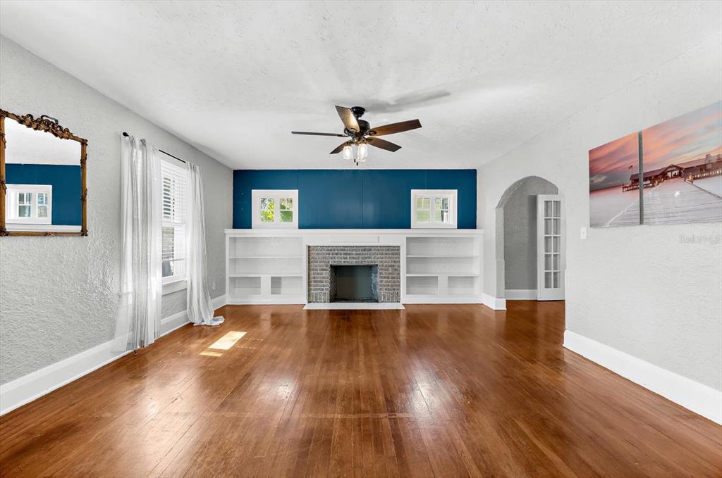 A living room features hardwood floors, a fireplace with built-in shelving, and a blue accent wall — 2726 8TH AVENUE W, BRADENTON, FL