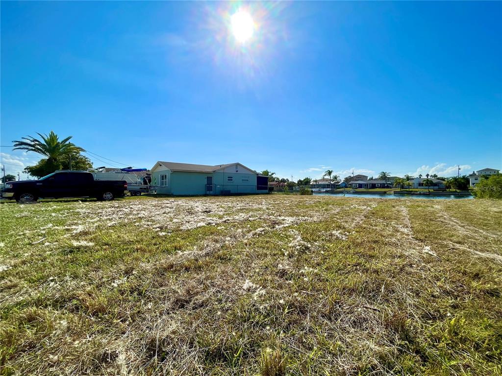 A vacant, grassy lot sits next to a house with a boat parked nearby — 0 POINSETTIA DRIVE, HERNANDO BEACH, FL
