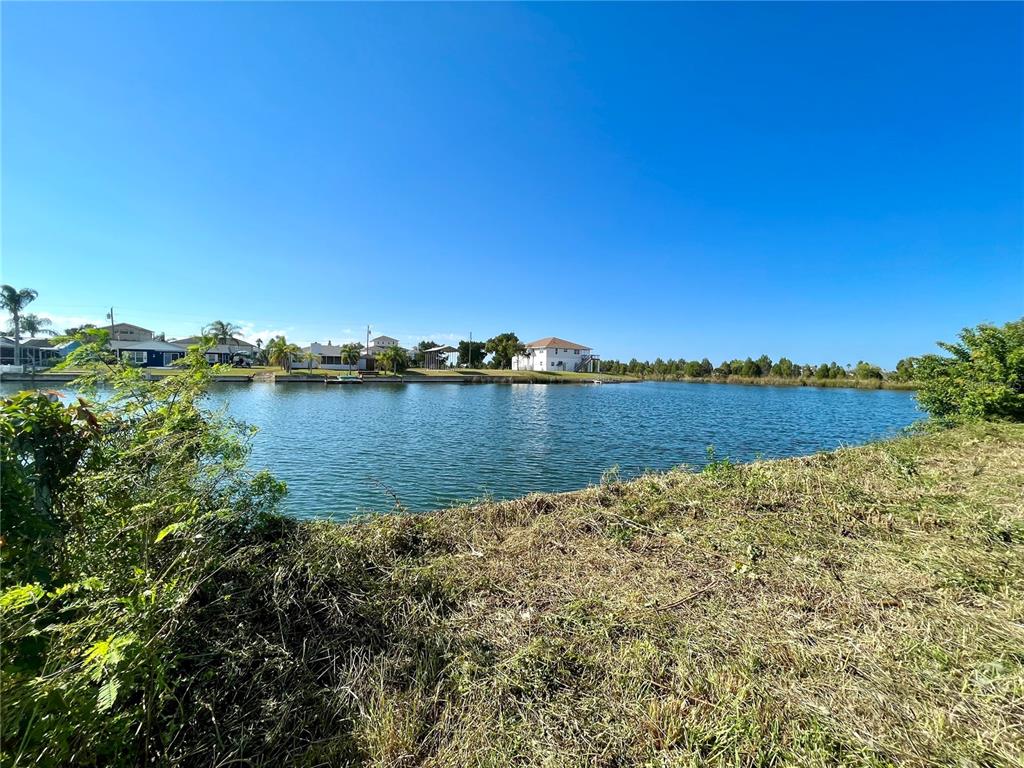 A view of a canal with houses in the background and a grassy foreground — 0 POINSETTIA DRIVE, HERNANDO BEACH, FL