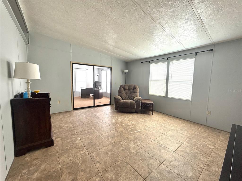 A kitchen features tan cabinets, a white refrigerator, a white stove, and a breakfast bar — 225 N SAINT THOMAS CIRCLE, APOLLO BEACH, FL