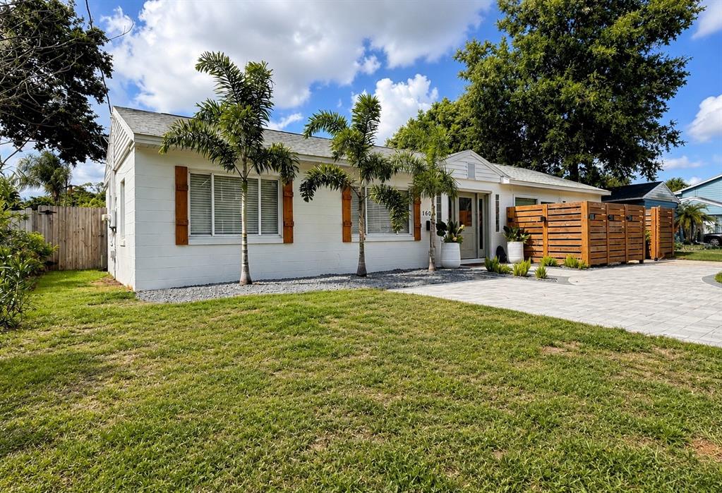 A white single-story house features palm trees, wooden shutters, and a wooden privacy fence — 1604 BRYN MAWR STREET, ORLANDO, FL
