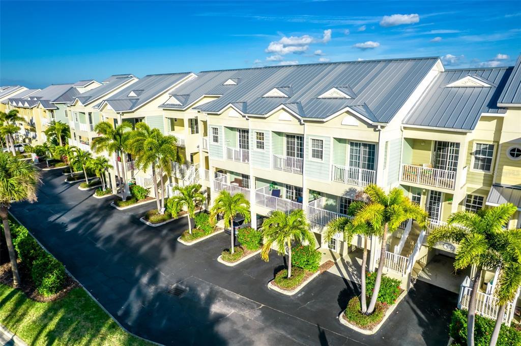 An aerial view of a multi-story residential building with palm trees and parking spaces — 515 BAHIA BEACH BOULEVARD, RUSKIN, FL