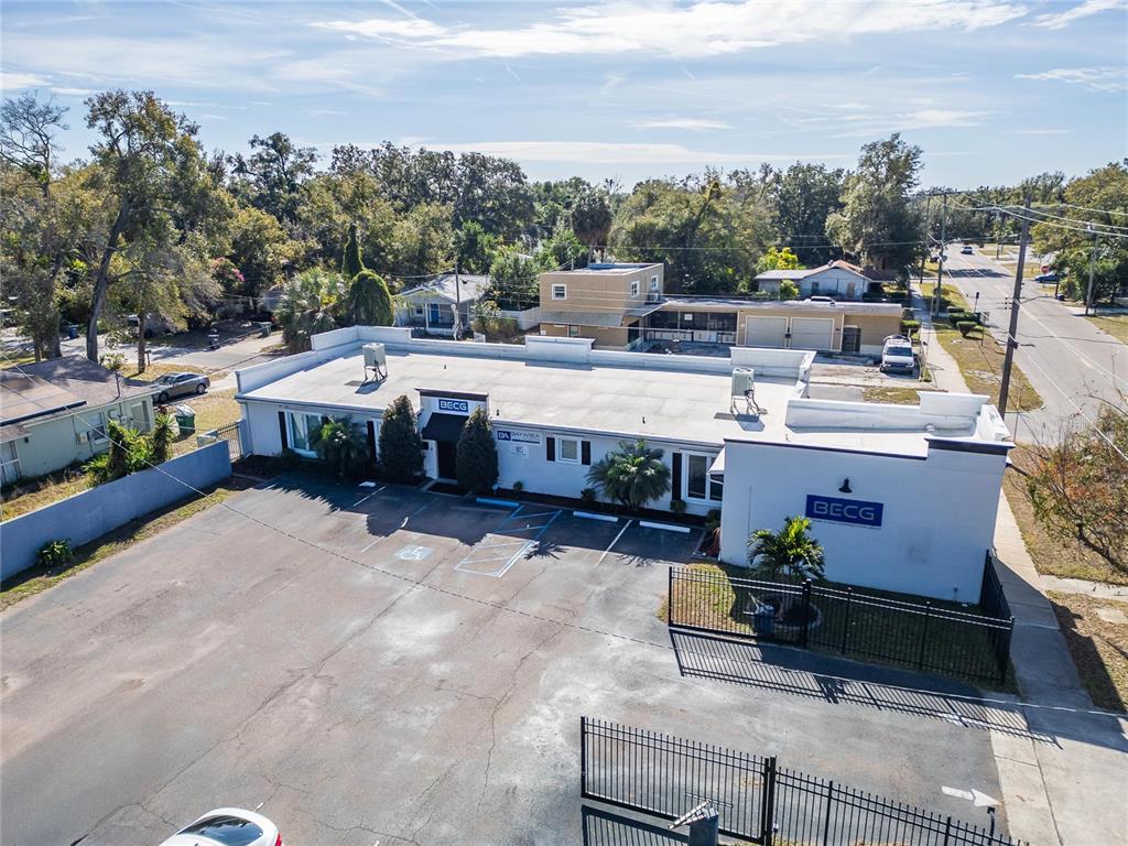 An aerial view of a white commercial building with a parking lot and metal fencing — 3411 N 29TH STREET, TAMPA, FL