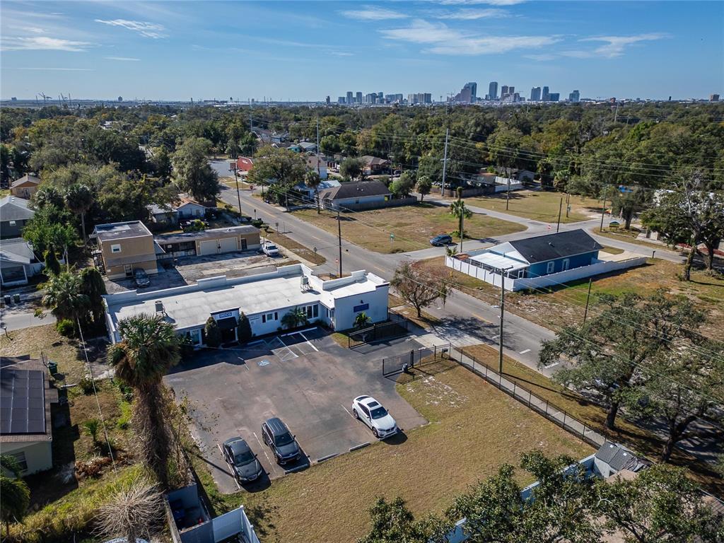 An aerial view shows a commercial building with a parking lot and a nearby house — 3411 N 29TH STREET, TAMPA, FL