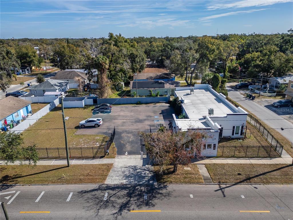 An aerial view shows a commercial building with a parking lot and fenced yard — 3411 N 29TH STREET, TAMPA, FL