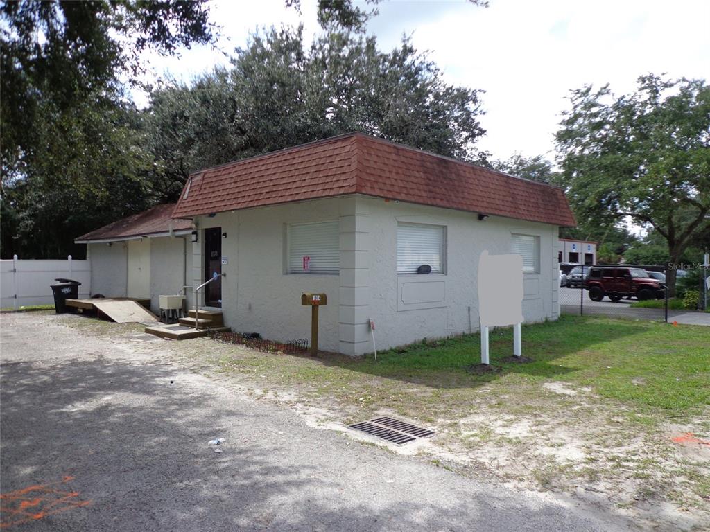 A single-story commercial building with a red shingled mansard roof and a gravel parking lot — 1904 W WATERS AVE, TAMPA, FL