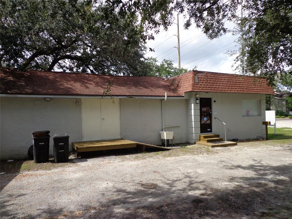 A single-story building with a brown shingled roof, double doors, and a small entrance porch — 1904 W WATERS AVE, TAMPA, FL