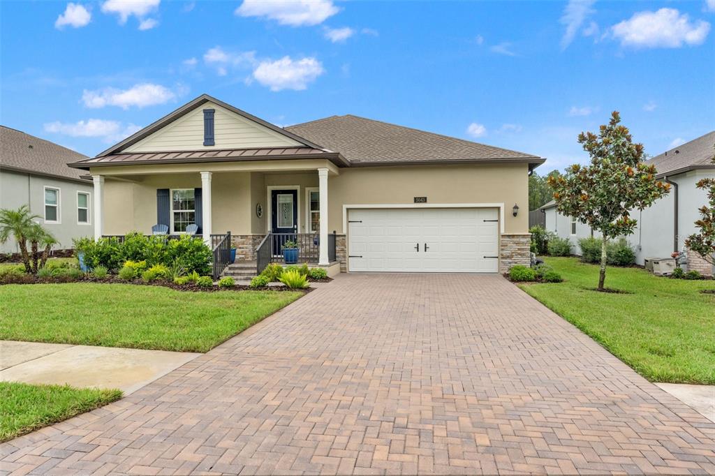 A single-story house with a paved driveway, a two-car garage, and a covered front porch — 5043 SOUTHERN VALLEY LOOP, BROOKSVILLE, FL