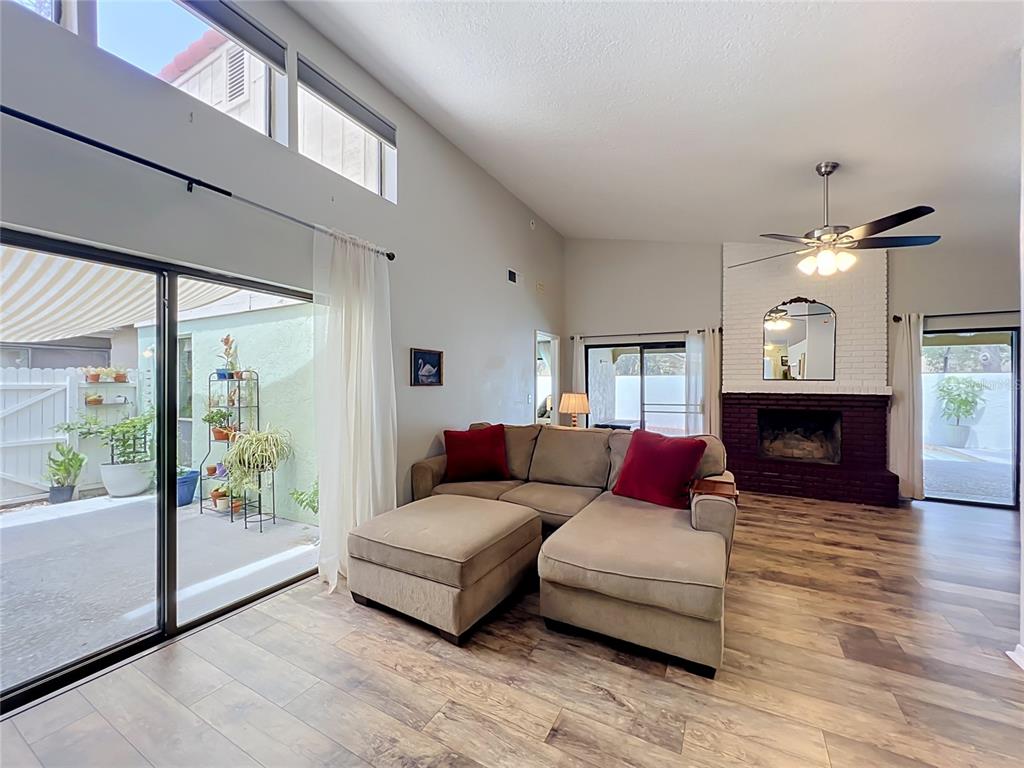 A living room features a sectional sofa, a brick fireplace, and sliding glass doors — 1162 E WINGED FOOT CIRCLE, WINTER SPRINGS, FL