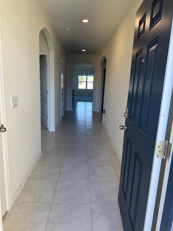 A single-story suburban house with a tan exterior, dark shutters, and an attached two-car garage — 528 BOARDWALK AVENUE, HAINES CITY, FL