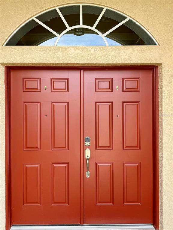 A red double front door with a semicircular transom window above it — 3735 GAVIOTA DRIVE, RUSKIN, FL