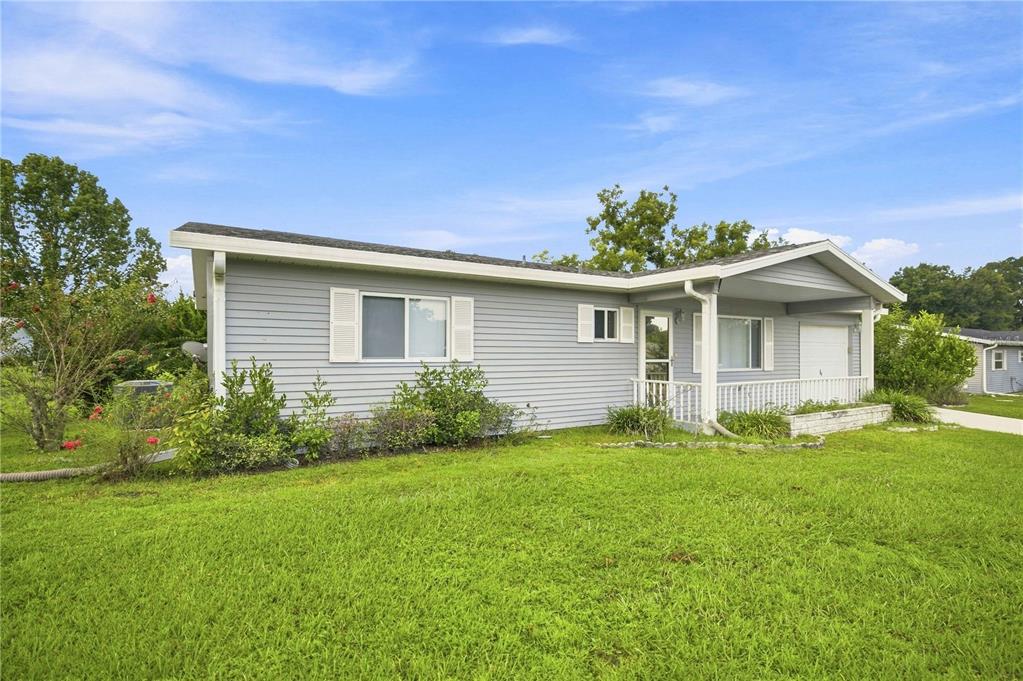 A light gray single-story house with a covered front porch sits on a grassy lawn — 6362 SW 106TH PLACE, OCALA, FL