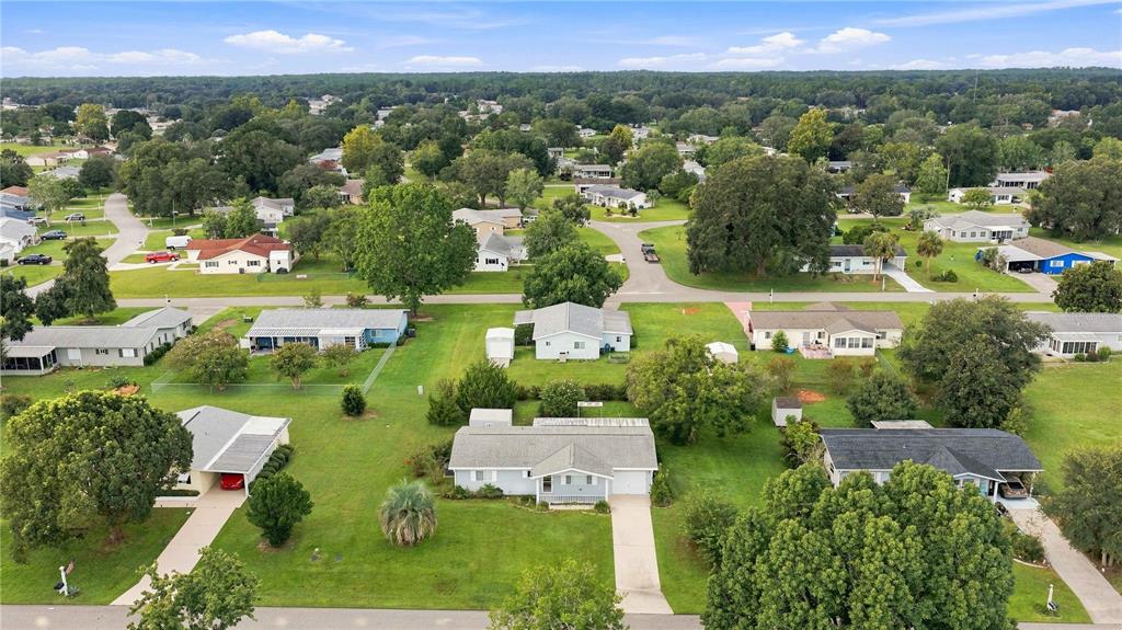 An aerial view shows a suburban neighborhood with single-story houses, green lawns, and mature trees — 6362 SW 106TH PLACE, OCALA, FL