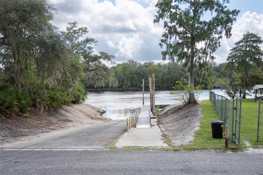 A concrete boat ramp leads into a river next to a small dock and trees — 227 NE 838TH STREET, OLD TOWN, FL