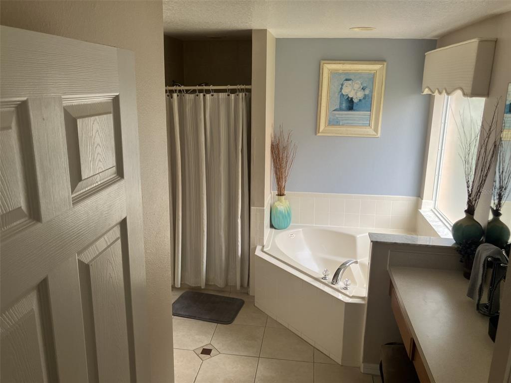 A foyer features a black console table, a mirror, and a staircase with carpeted steps — 345 SOLANA CIRCLE, DAVENPORT, FL