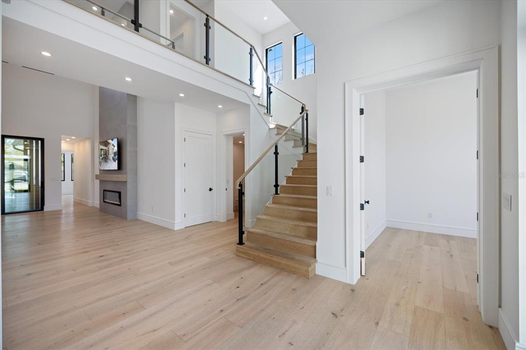 A modern home entrance features a black double door, white vertical siding, and stone accents — 2045 GOLDENROD STREET, SARASOTA, FL