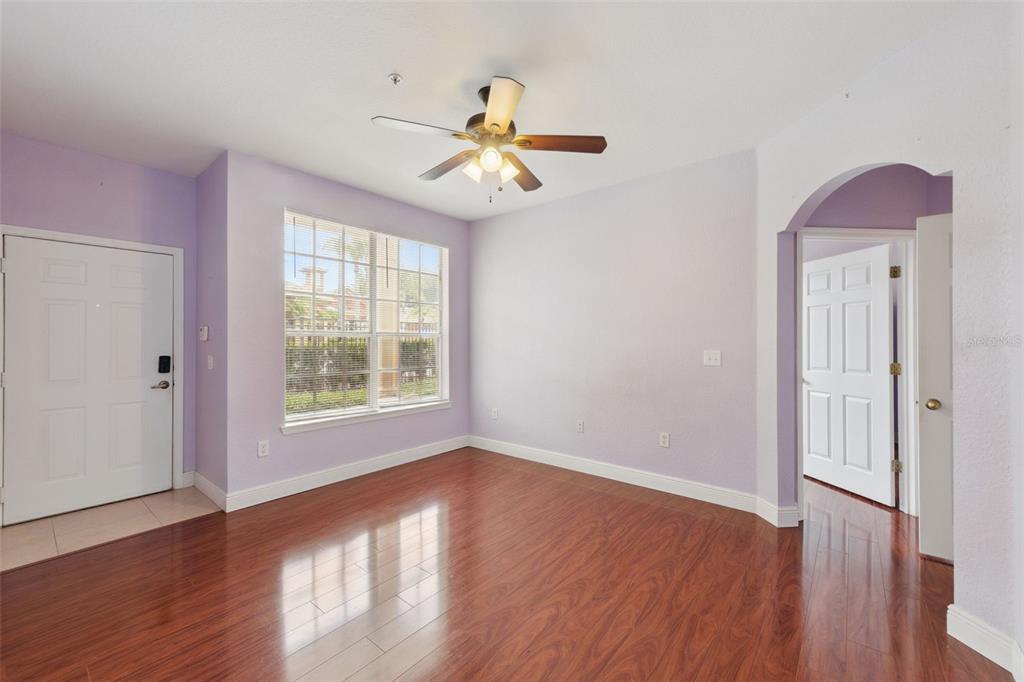A room with light purple walls, dark wood flooring, a ceiling fan, and a white door — 832 GRAND REGENCY POINTE POINT UNIT 105, ALTAMONTE SPRINGS, FL