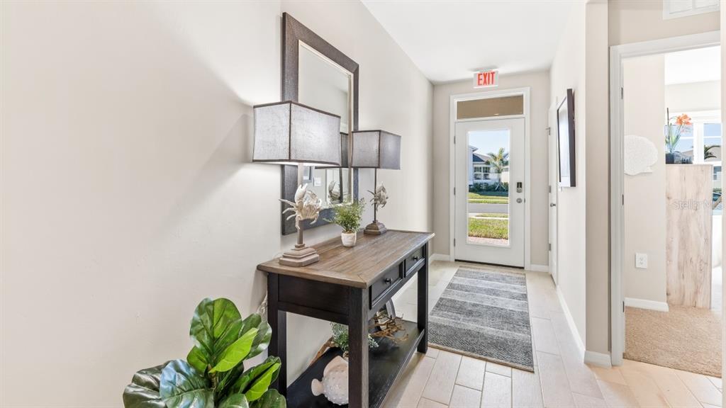 An entryway features a wooden console table, two lamps, a mirror, and a glass door — 9626 TURTLE GRASS CIRCLE, PUNTA GORDA, FL