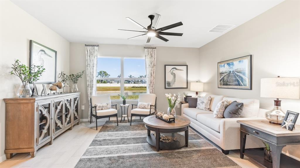A living room features a beige sofa, two armchairs, a coffee table, and a sideboard — 9626 TURTLE GRASS CIRCLE, PUNTA GORDA, FL