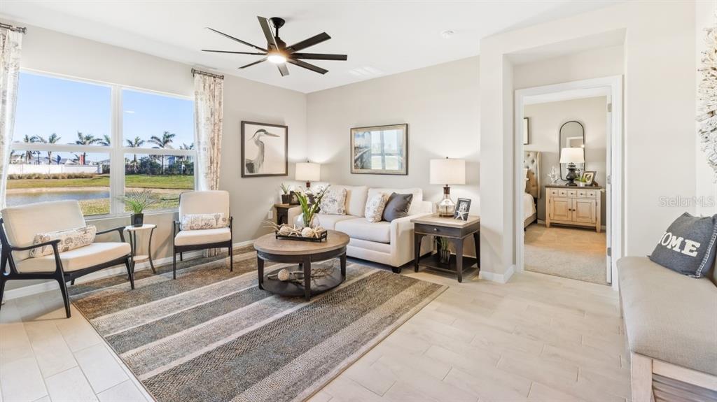 A living room features a sofa, two armchairs, a coffee table, and a ceiling fan — 9626 TURTLE GRASS CIRCLE, PUNTA GORDA, FL