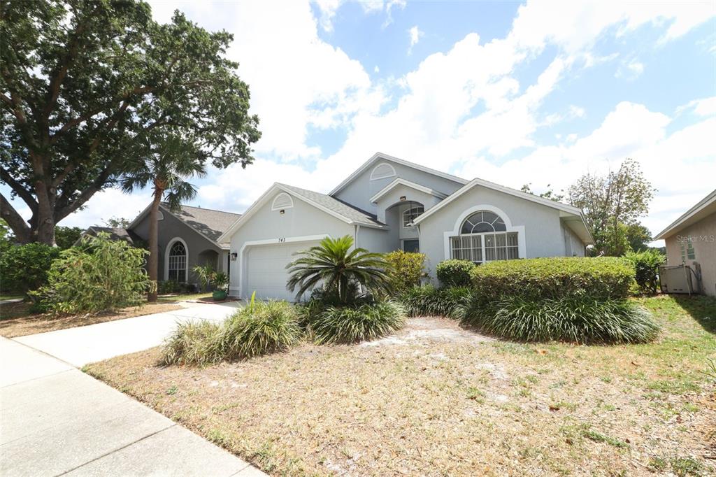 A single-story house with a gray exterior, a two-car garage, and a landscaped front yard — 743 DEACON WINN COURT, ORLANDO, FL