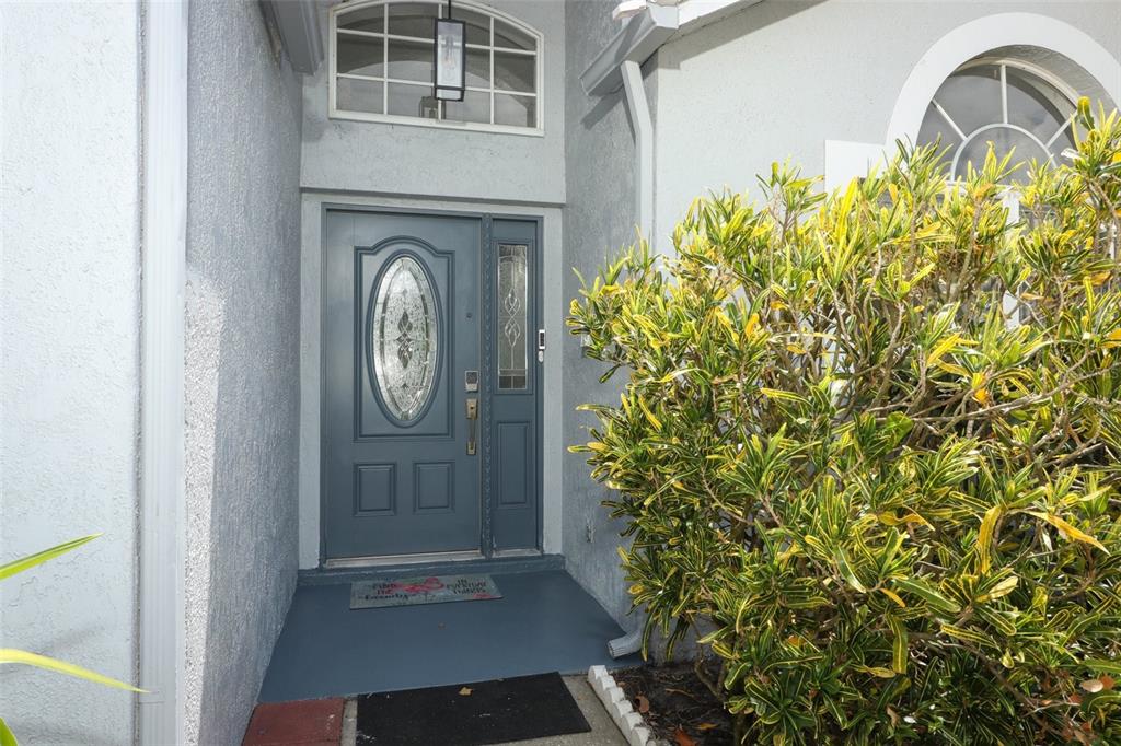 A blue front door with a glass oval insert sits under an arched transom window — 743 DEACON WINN COURT, ORLANDO, FL