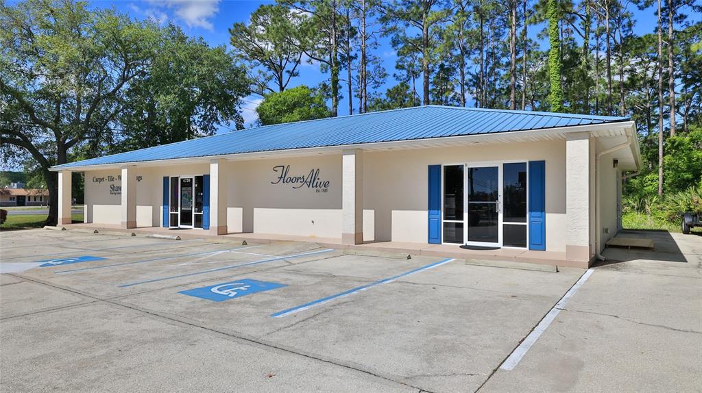 A single-story commercial building with a blue metal roof and a paved parking lot — 4720 E MOODY BOULEVARD, BUNNELL, FL