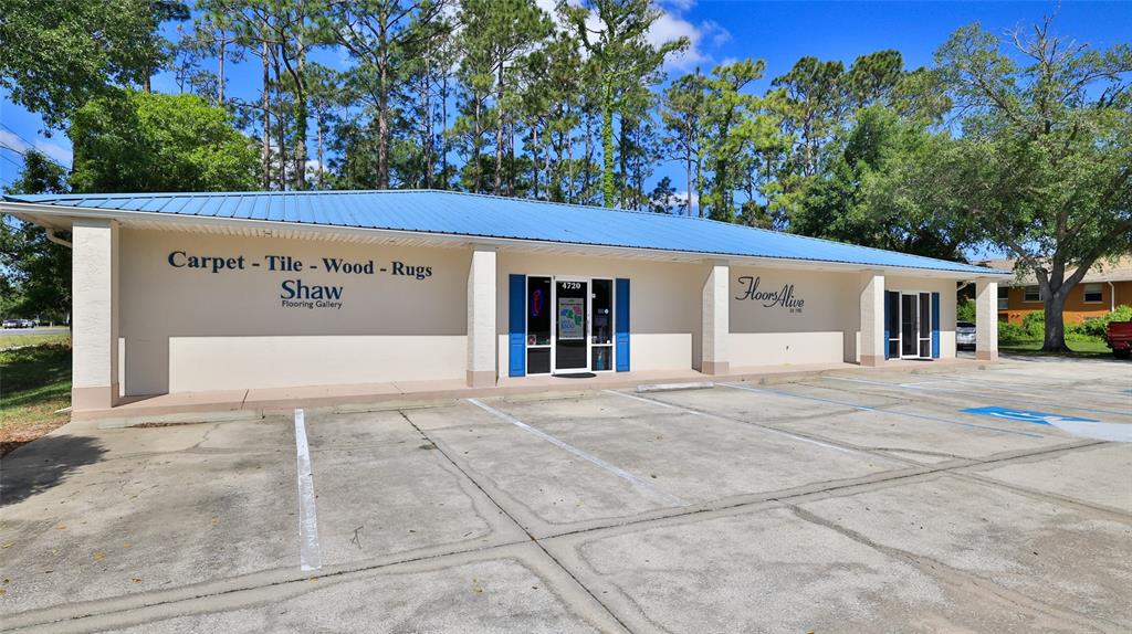 A single-story commercial building with a blue metal roof and a concrete parking lot — 4720 E MOODY BOULEVARD, BUNNELL, FL