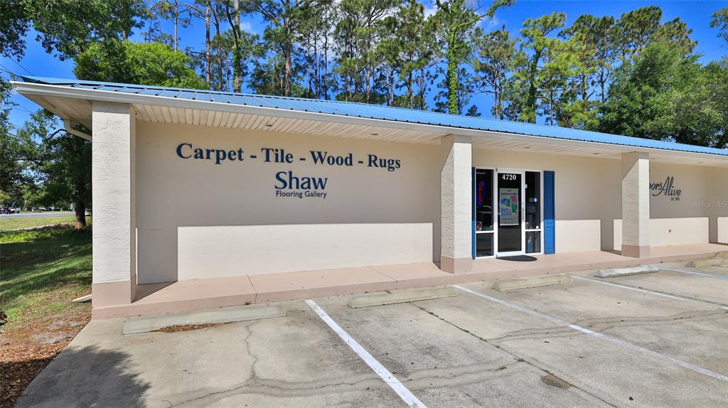 A single-story commercial building with a blue metal roof and a parking lot in front — 4720 E MOODY BOULEVARD, BUNNELL, FL